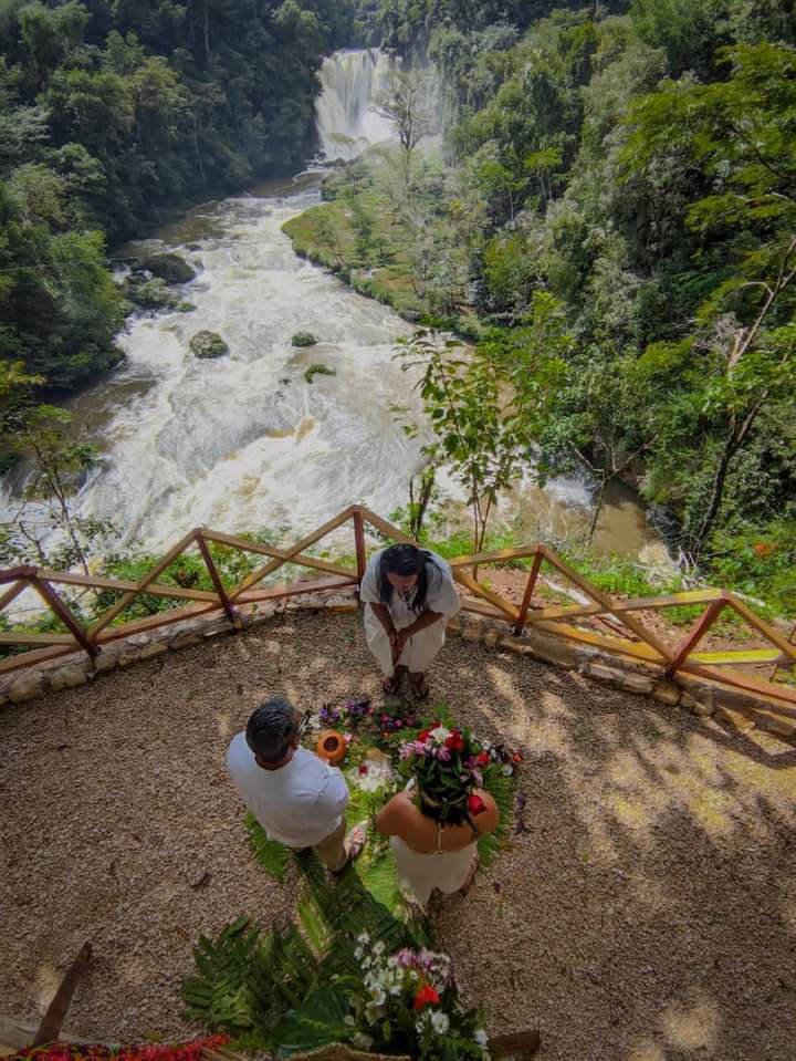 Pareja con vestimenta tradicional de boda maya junto a un cenote sagrado en Chiapas.