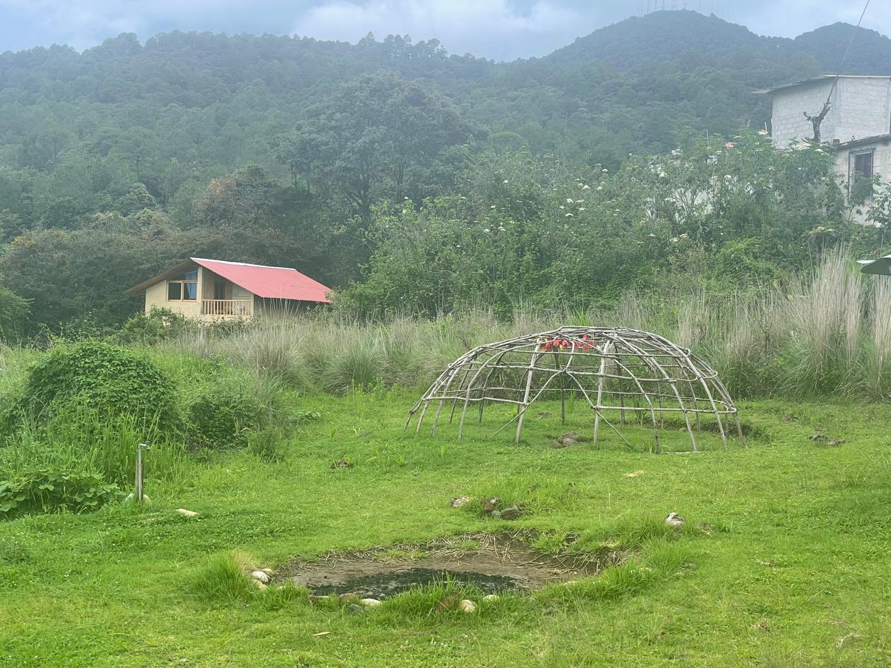 Participants sitting in circle outside a temazcal after the ceremony, sharing tea and grounding.